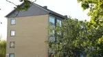 Endegavl på bygning og stort grønt tre i boligafdelingen Pinjeparken
