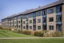 Lejlighedskompleks med græsplæne og sti i boligafdelingen Munkebo