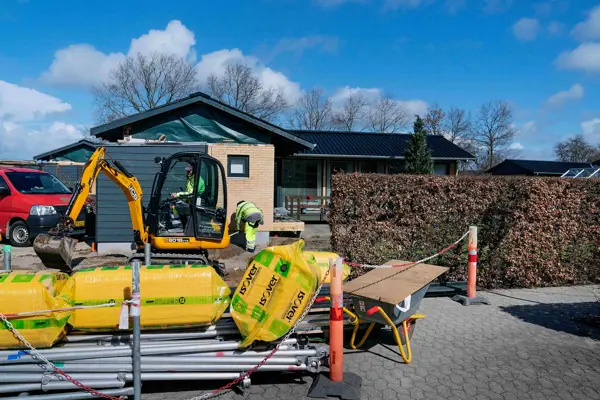 Gravko og byggematerialer ligger på fortovet foran et hus